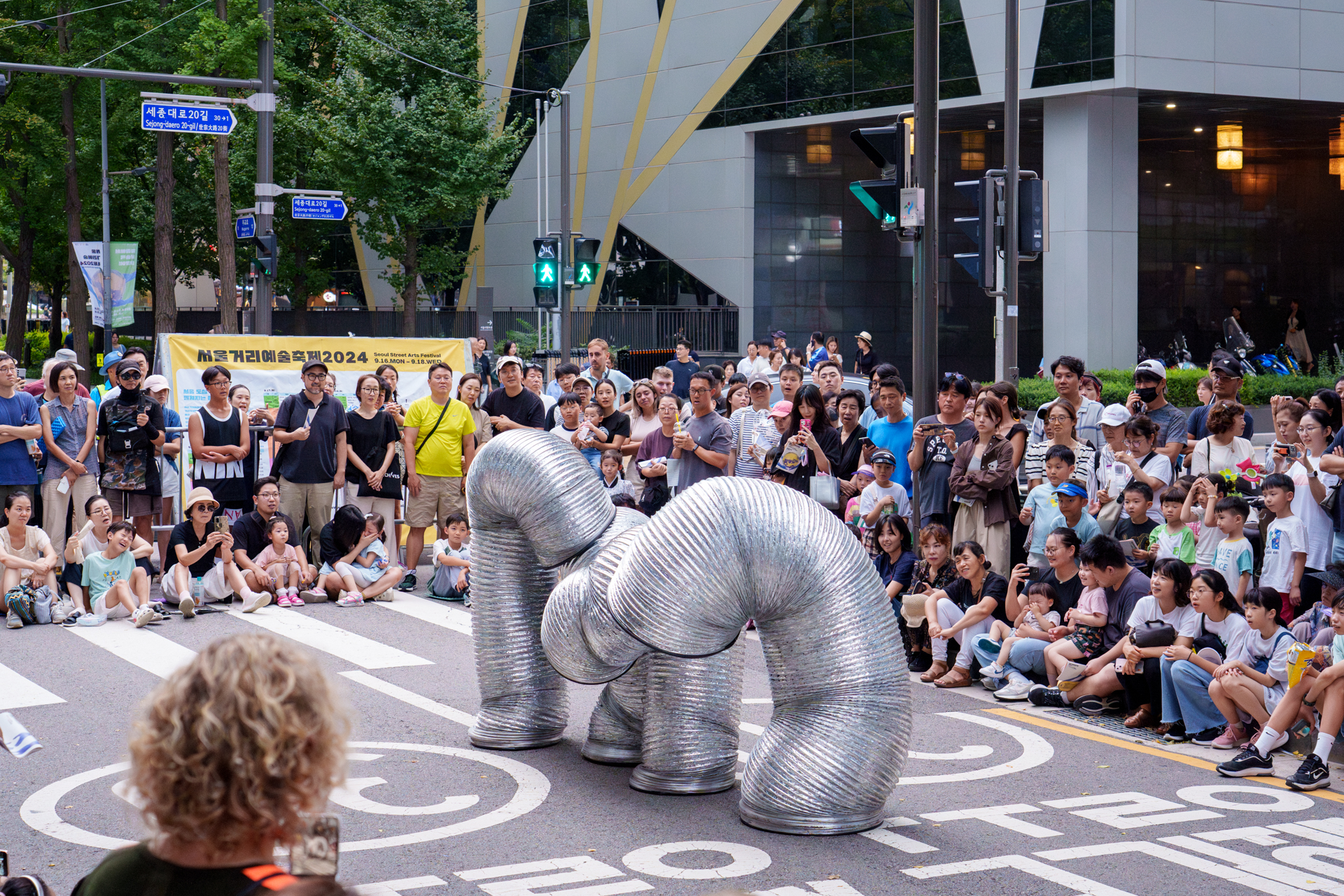 A majestic parade of hyper flexible interactive slinkies with bursts of comic energy amongst the crowd.